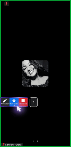 The image shows a smartphone screen during a Zoom meeting with a green border indicating active screen sharing. A portrait of a smiling woman is displayed, and the bottom menu features buttons for "Annotation," "Share audio," and "Stop share," highlighted by an arrow pointing towards the "Stop share" button, suggesting it is the next action to be taken.