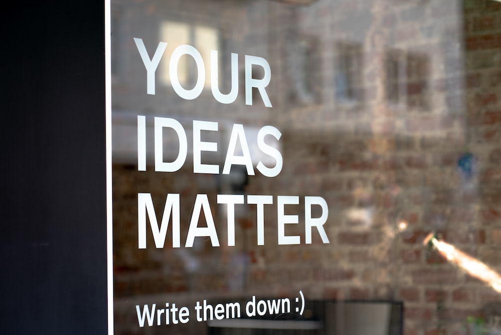 a sign on the side of a building motivating content creation, saying: Your ideas matter, write them down