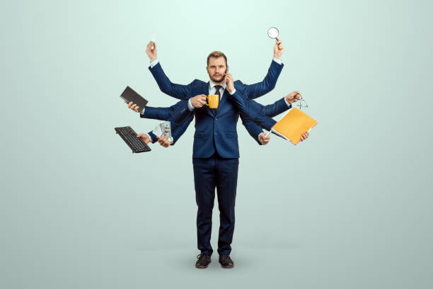 businessman with many hands in a suit. works simultaneously with different objects, a mug, a magnifying glass, papers, a contract, a telephone. multitasking, efficient business worker concept. - multitasking stock photos and images.