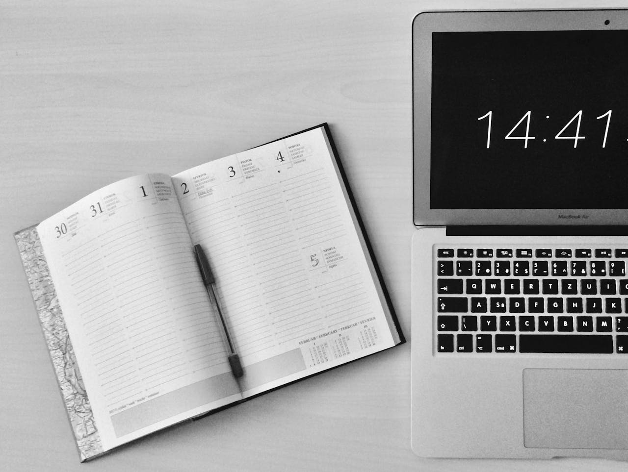 image showing laptop and agenda for writing meeting minutes