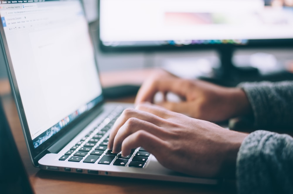 person using MacBook Pro for social media content creation