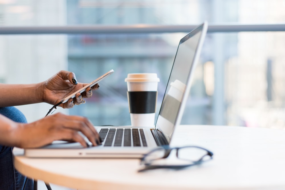 person using smartphone and MacBook computer , remote closing jobs