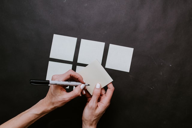 person writing words on multiple postits