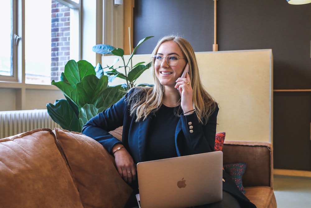 woman in blue long sleeve shirt using silver macbook, doing remote closing jobs